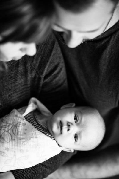 Mom and dad gaze at swaddled newborn