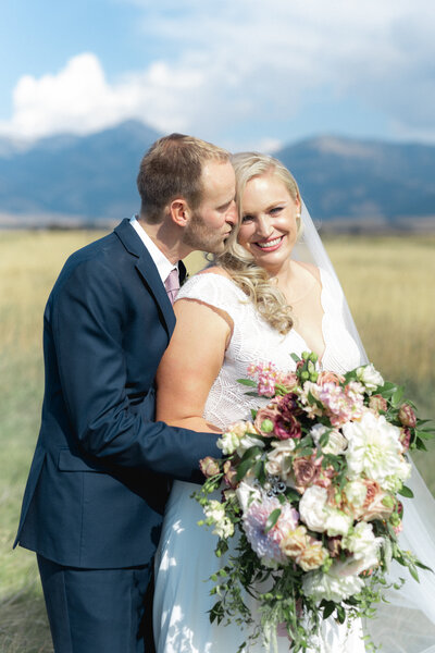 Bride and groom hold hands at city wedding