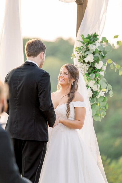 Bride and groom smile as they make their wedding vows
