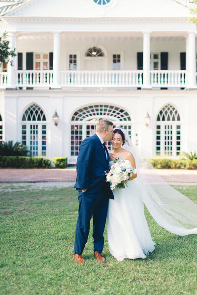 couple in charleston in front of venue kissins forehead