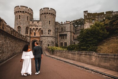 Couple walks hand in hand towards an ornate and historic castle