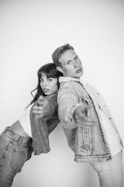 male and female model back to back reaching hands towards the camera taken by Seattle Portrait Photographer
