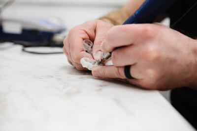 Prosthodontist crafting custom clear aligners to enhance smile alignment at Peak Prosthodontics in Lethbridge.