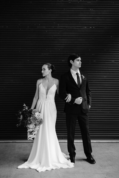 Indoor back and white portrait of bride and groom at Wildman BT against the garage door. 