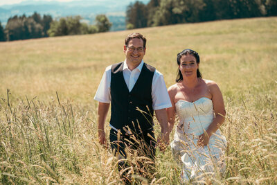 Ein verliebtes Brautpaar spaziert durch ein malerisches Kornfeld und teilt innige Blicke, während sie ihre Liebe in der Natur feiern.