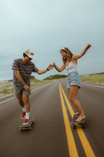 couple skateboarding down road