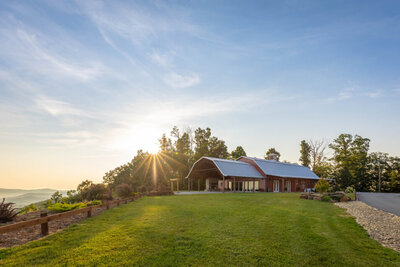 Distant shot from the grass of the modern red rustic barn.