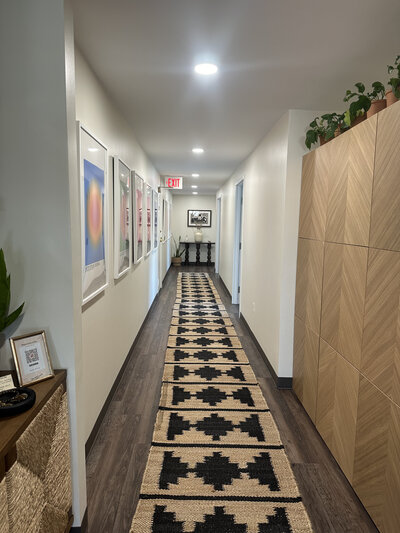Gallery-style hallway with framed artwork and warm lighting at 1440 Health Collective