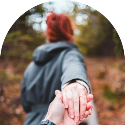couple holding hands in woods