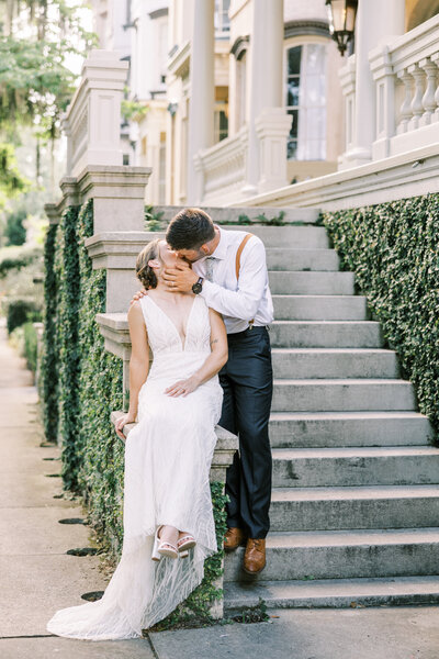 bride and groom kissing on stairs at forsyth park wedding