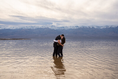 A couple hugging while standing in shallow water