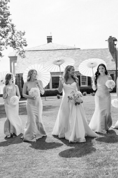 Bride with bridesmaids holding parisols