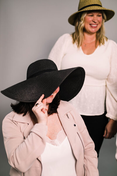 A woman hiding her face behind a hat