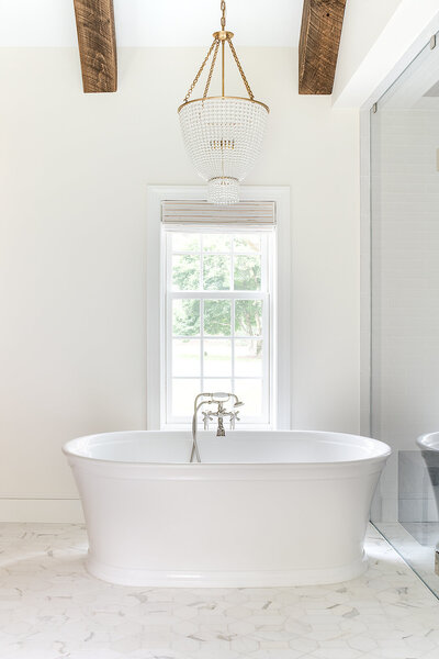 bright bathroom with bathtub and window overlooking outside in the middle