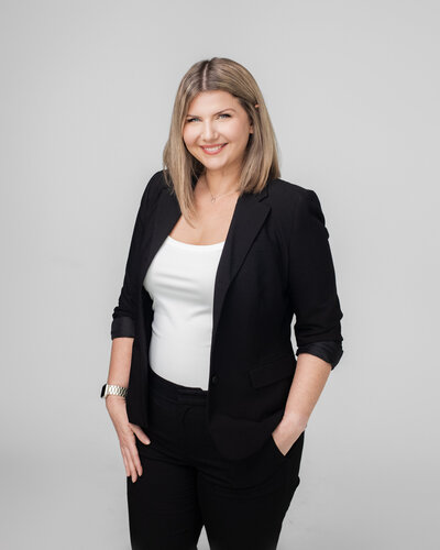 Karlie Cirocco standing in a black suit with white shirt smiling