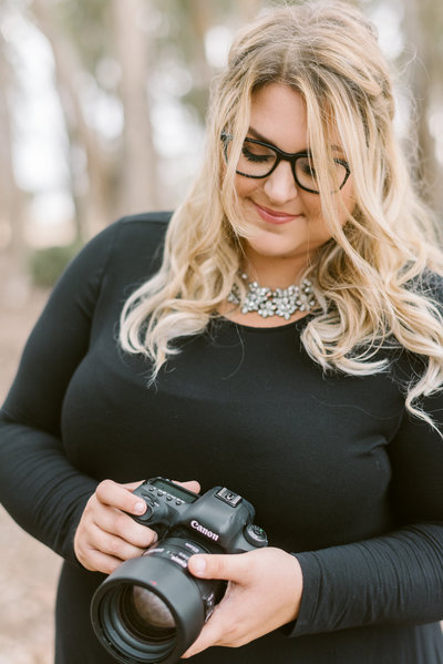 Headshot of Paige Hill Photography holding a camera