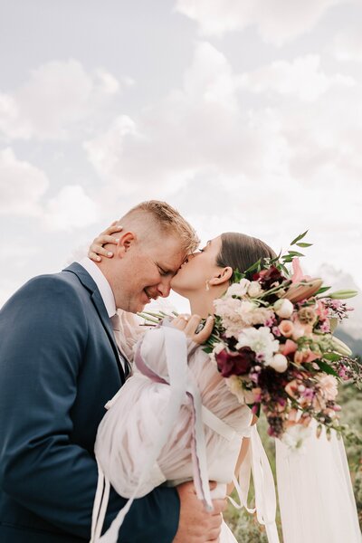 groom and bride standing next to their wedding cake at their wedding venue taken by jackson hole wedding photographer adrian wayment photo