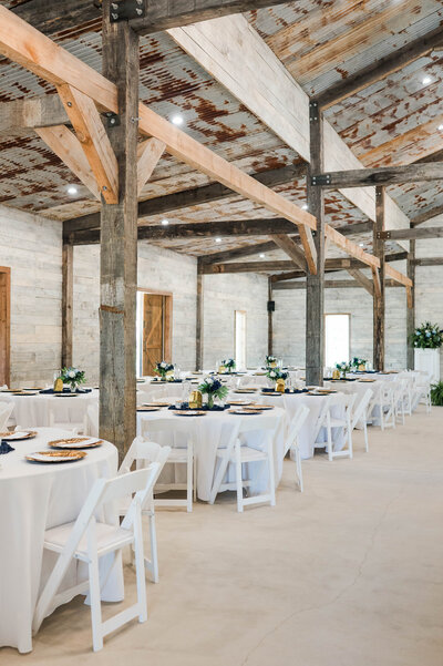 Indoor reception setup at The Grove with farmhouse tables, elegant lighting, and western-modern décor.