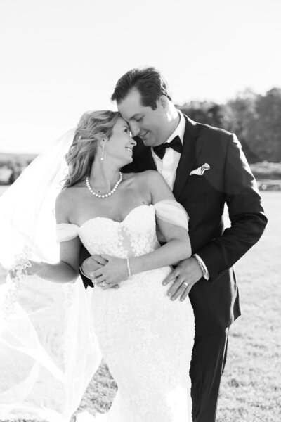 Photo of bride and groom hugging.