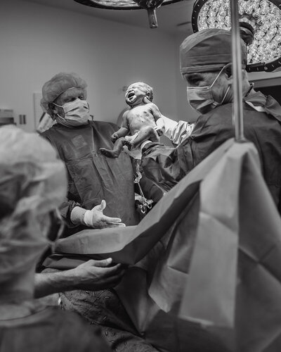 C-section photos in Indianapolis, baby being held up after being born