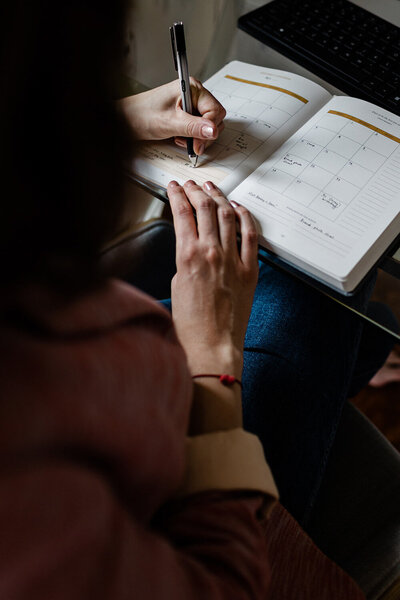Andrea Shah wiring on her notebook using her black pen