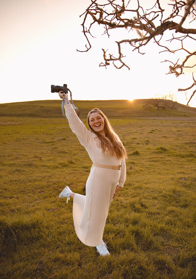 woman holding camera in the air
