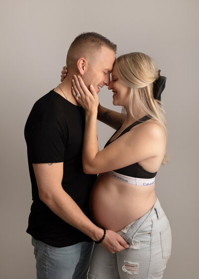 pregnant mom with her husband embracing in our denver studio