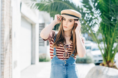 Senior girl in striped shirt and hat during a sunlit portrait session in Venice Beach