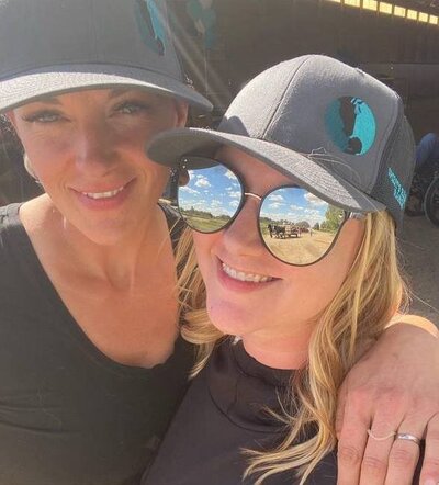 Two women wearing hats, exclusive merch from Spirit’s Respite Ranch that helps support programs and animal care