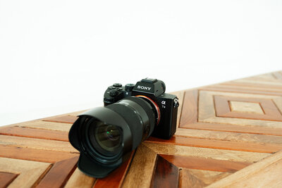 Adriana Montoya Photo's camera sitting on a decorative table in a white studio.