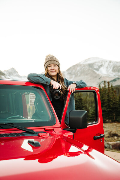 women in a black shirt and jeans sitting on a stole with a black cowboy hat