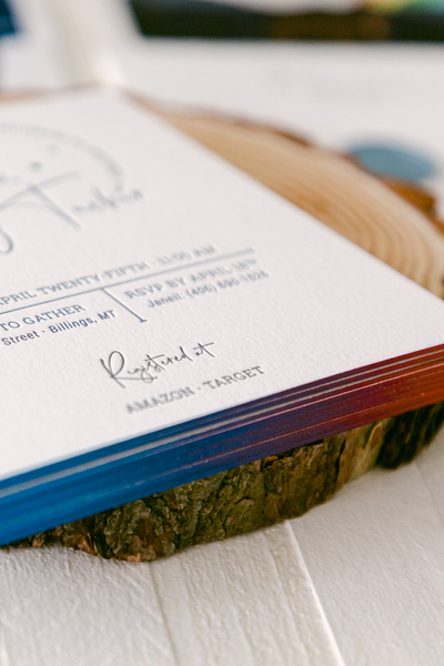 Hand-painted rainbow edges on a letterpress baby shower invitation, showcasing creative invitation ideas with a vibrant and personalized touch.