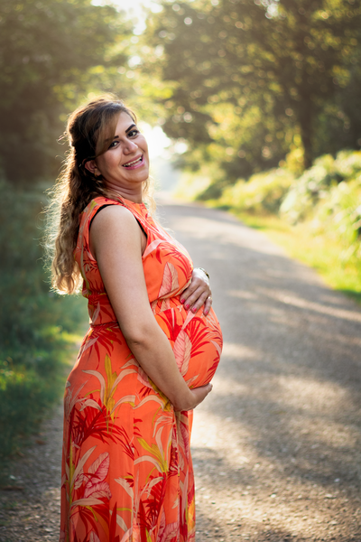 Blue-eyed brunette pregnant woman sincerely smiles and looks into camera.  Charming lady in plaid sh Stock Photo by look_studio