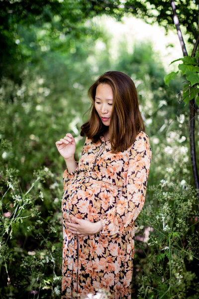 Pregnant woman in front of greenery