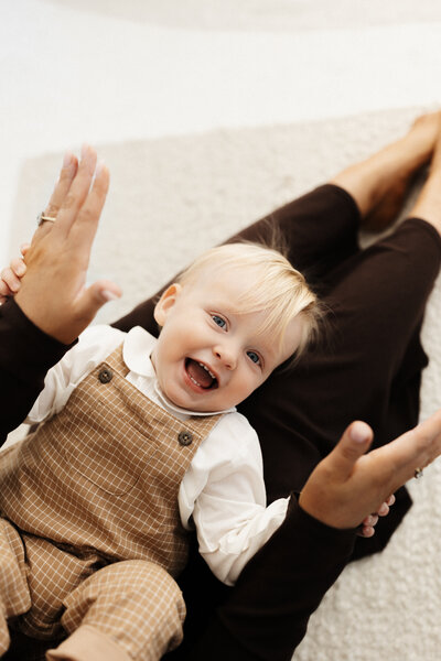 A little boy playing peekaboo while photographed by lucy jane photography in christchurch