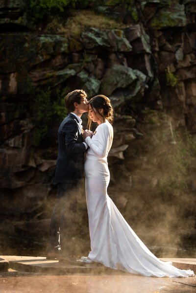 Bride and groom embrace after exchanging vows at River Bend wedding venue in Lyons, Colorado.
