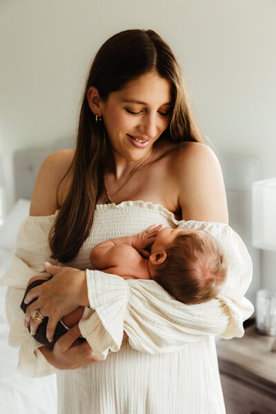 A mother gazes down at her newborn son during  their newborn photography session in Madison WI.