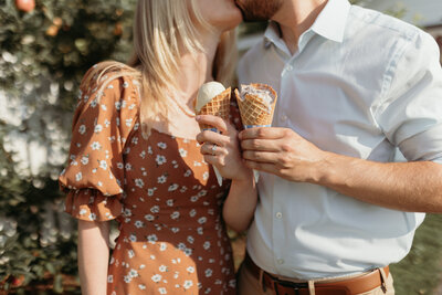 A couple eats an ice cream cone on a hot summer day