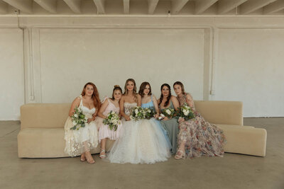 Bride and Bridesmaids sitting on curvy couch