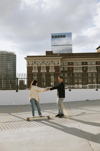 A couple longboarding on a rooftop parking garage in Grand Rapids, Michigan. 