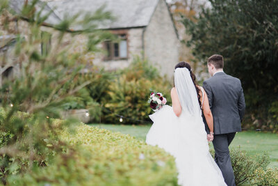 A couple walking away from the camera towards their wedding venue taken by Cornwall Wedding Photographer and Devon Wedding Photographer Liberty Pearl