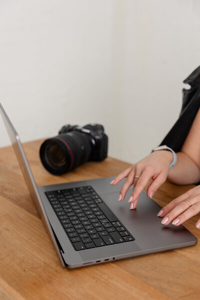 a woman types on a laptop