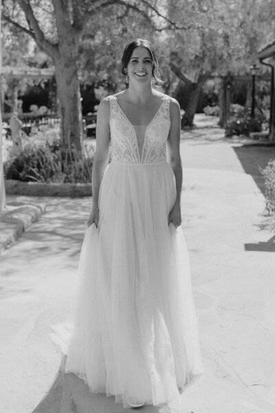 Black and white photo of bride walking up to the first look on her wedding day.
