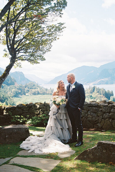 A bride and groom smile at one another at the Griffin House venue, representing the photo style of Oregon Wedding Photographer Among the Oaks. 