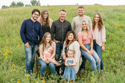 A large family posing for the camera in a grassy field