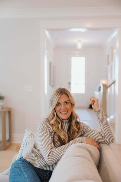 Jessica McKenna, Raleigh Realtor sitting on couch in open house.