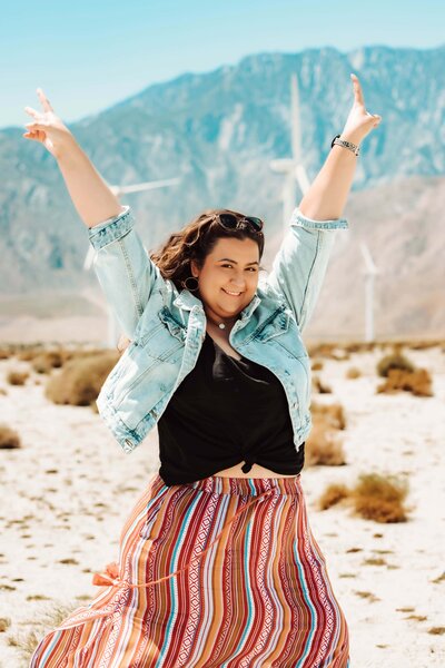 Morgen Hooper, Orange County photographer, standing in the desert with her arms in the air