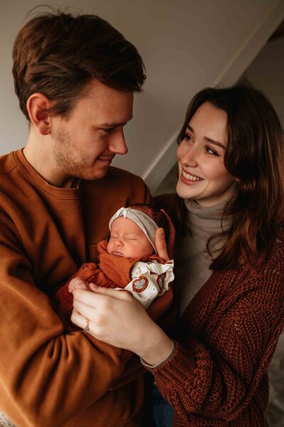 Tijdloze en elegante newbornfoto’s van een pasgeboren baby, professioneel vastgelegd in een warme en rustige setting.