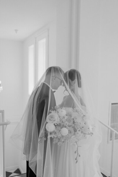 bride and groom looking at one another under her veil
