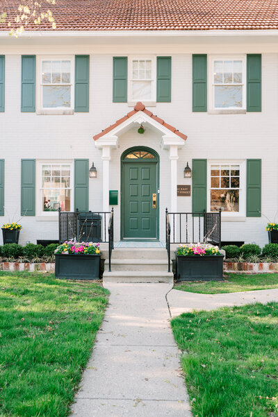 a white house with a green door and green shutters